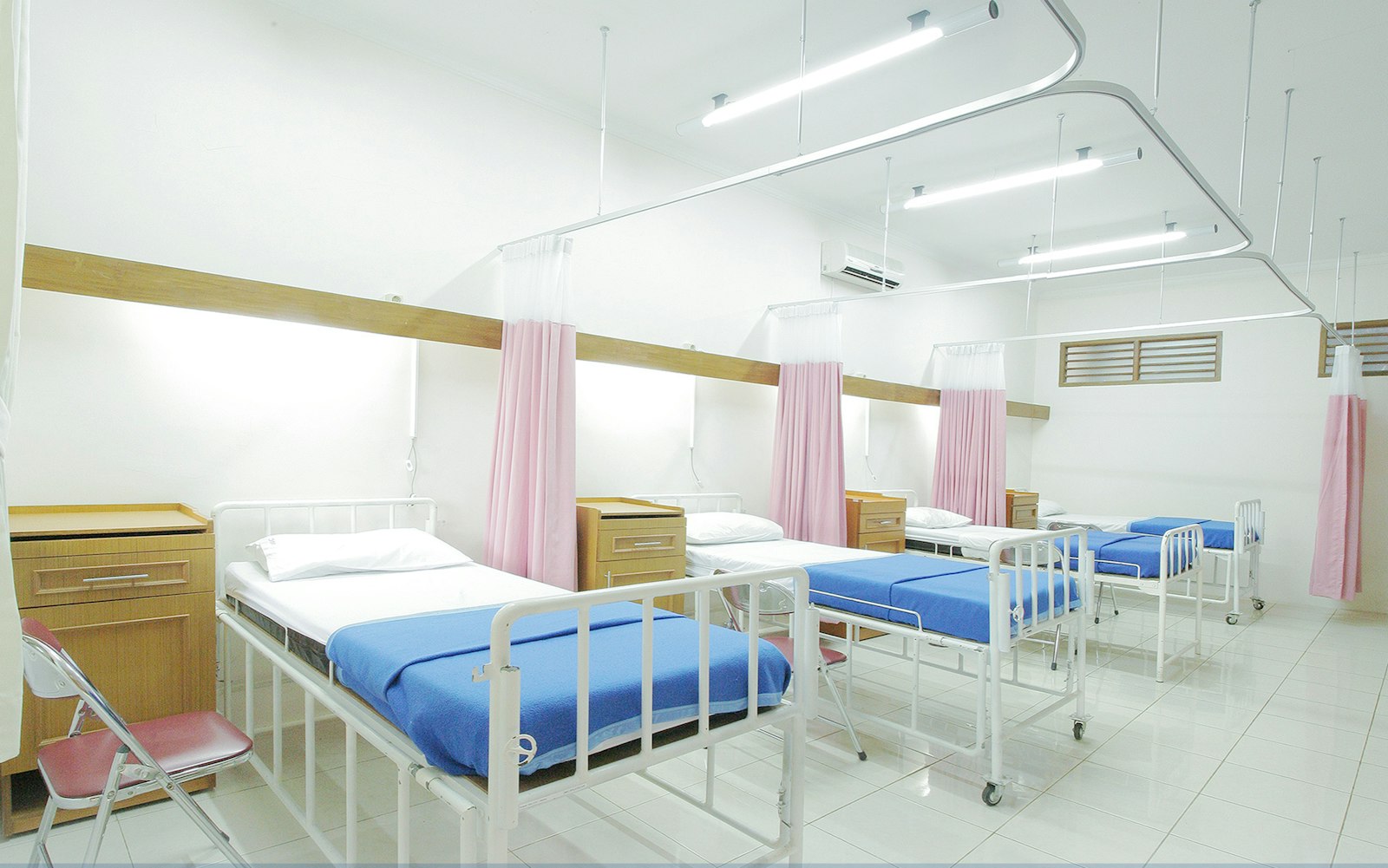 Empty hospital ward with beds and privacy curtains