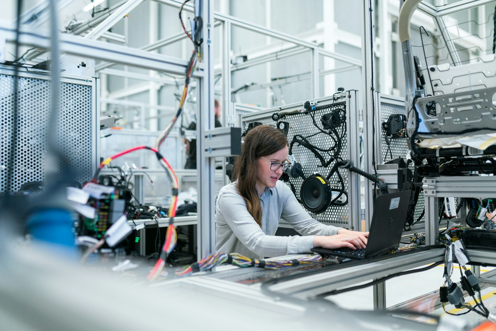 Engineer working on a laptop at a wiring test rig
