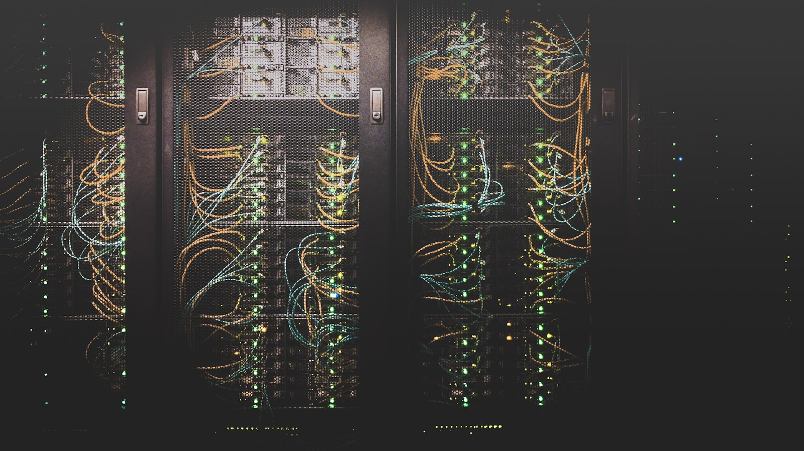 Server racks with network cabling glowing in a dark data center
